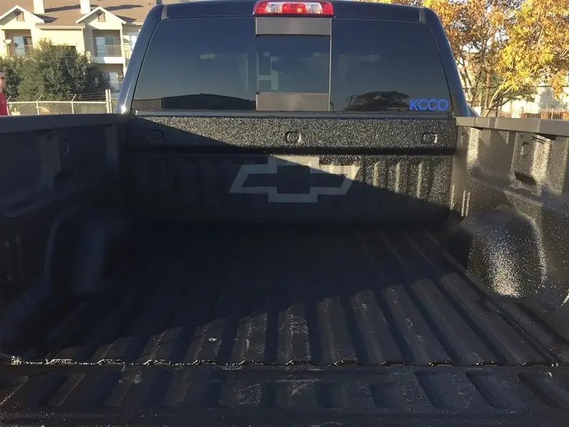 A truck with the back of it's bed in the sun.